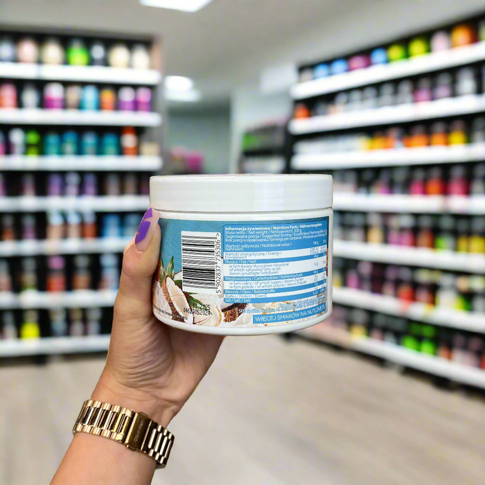 Close-up of (Allnutrition Nutlove Coco Crunch 500g) held up inside My Supplement Shop, clearly showing Nutritional Values on the packaging in a Sports Nutrition setting.