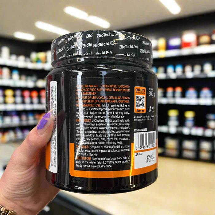 Close-up of (BioTechUSA Citrulline Malate, Green Apple - 300 grams) held up inside My Supplement Shop, clearly showing key ingredients on the packaging in a Sports Nutrition setting.