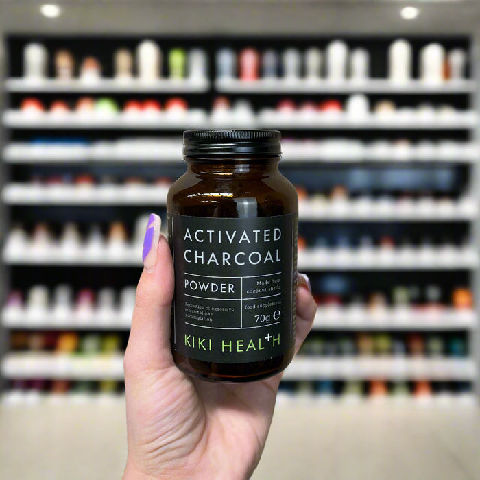 Close-up of (Kiki Health Activated Charcoal Powder 70g) held up inside My Supplement Shop, clearly showing the front label in a Sports Nutrition setting.