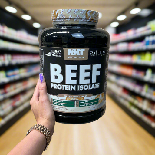 Close-up of (NXT Nutrition Beef Protein Isolate 1.8kg) held up inside My Supplement Shop, clearly showing the front label in a Sports Nutrition setting.