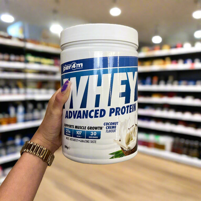 Close-up of (PER4M Whey Protein Powder 900g) held up inside My Supplement Shop, clearly showing the front label in a Sports Nutrition setting.