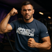Man wearing Applied Nutrition t-shirt striking a strong pose in a gym with moody MSS purple lighting in the background